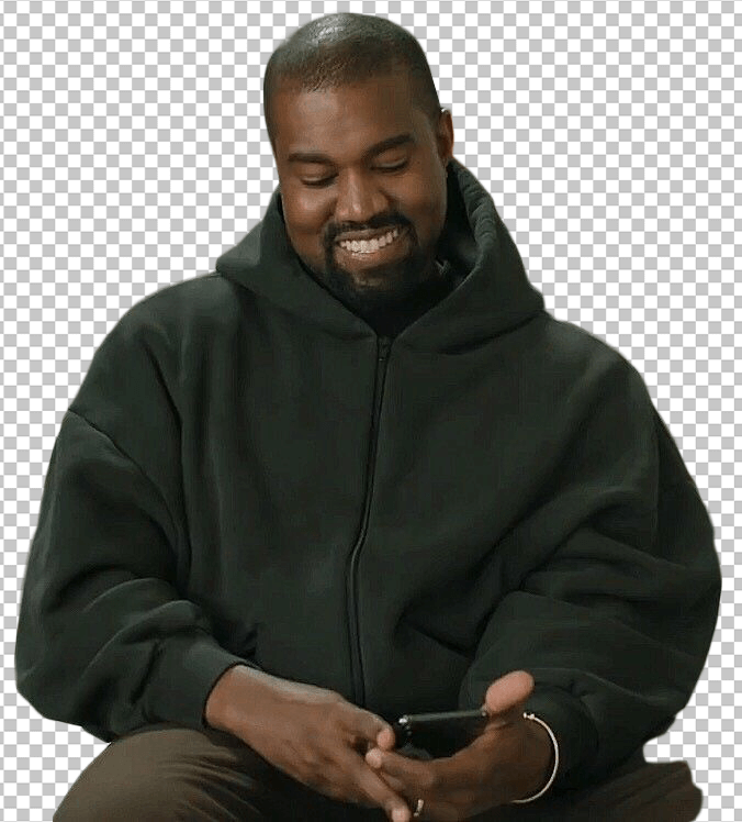 Kanye West sitting and smiling while looking at the phone transparent image