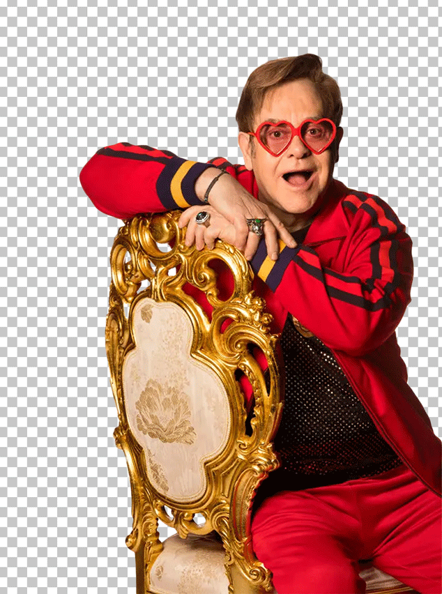 Elton John is sitting on a gold chair.