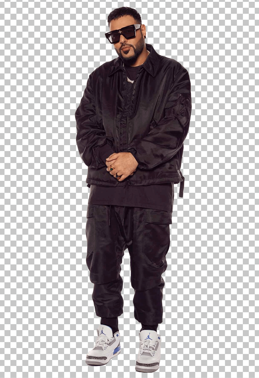 Badshah is wearing a black jacket, black pants, and white sneakers.