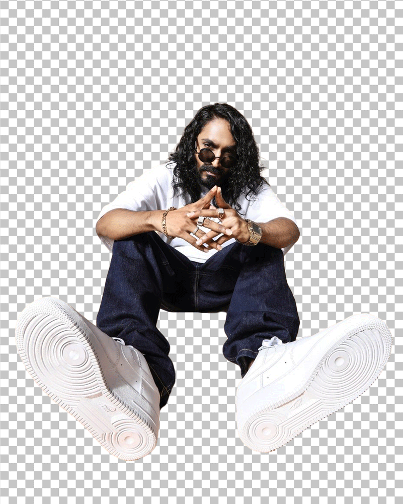 Emiway Bantai Sitting on the ground with his hands resting on his knees PNG Image