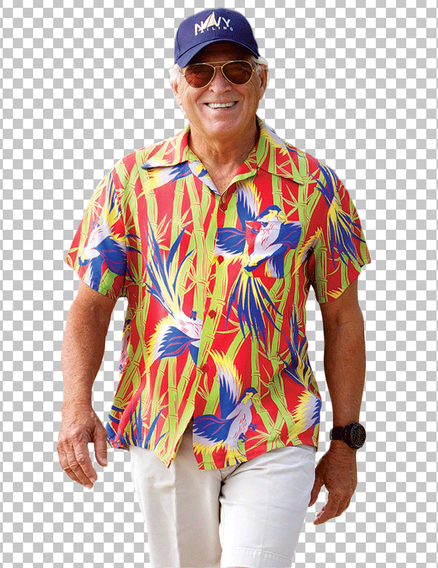 Jimmy Buffett is smiling and walking in colorful Hawaiian shirt and white pants.
