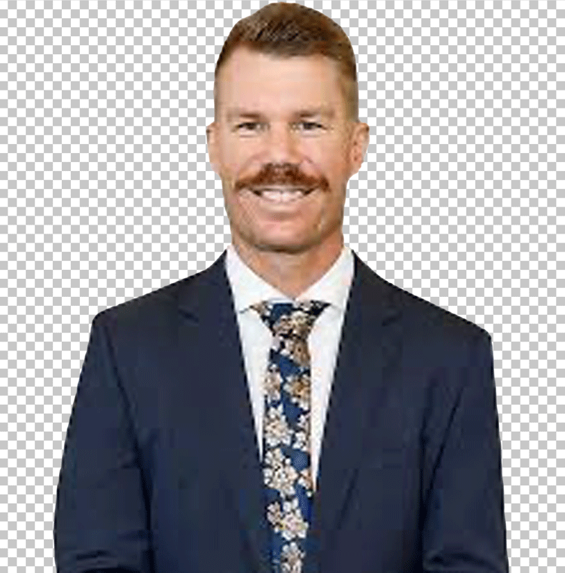 David Warner is smiling in a suit and tie.