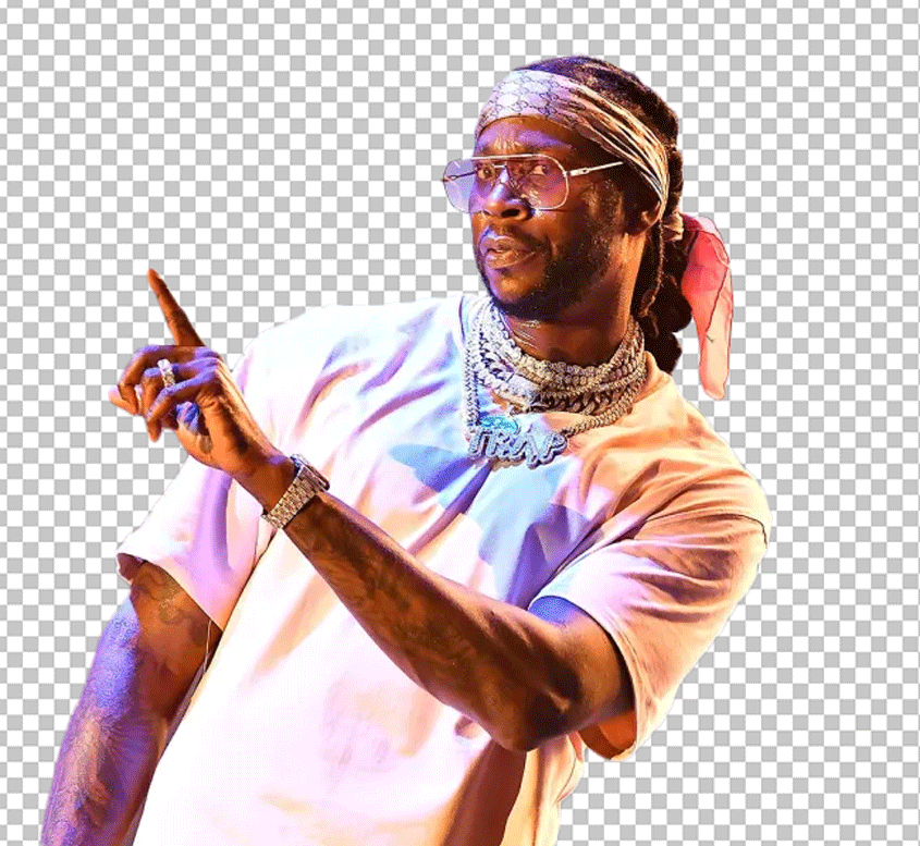 2 Chainz is wearing sunglasses and a pink shirt, pointing at something with his hand.