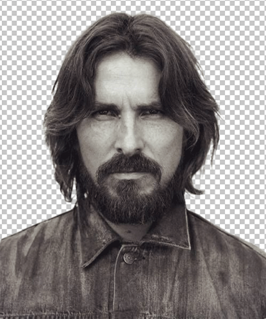 Christian Bale with a beard and long hair, is wearing a denim jacket.