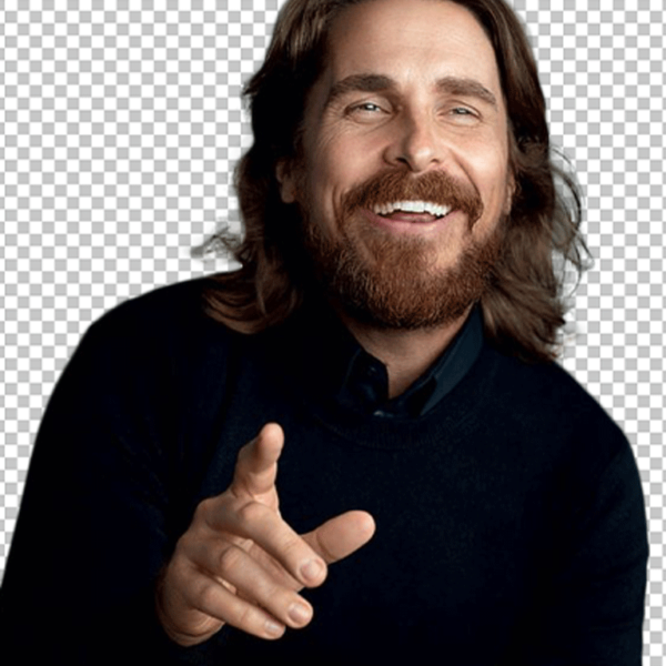 Christian Bale is smiling and pointing.