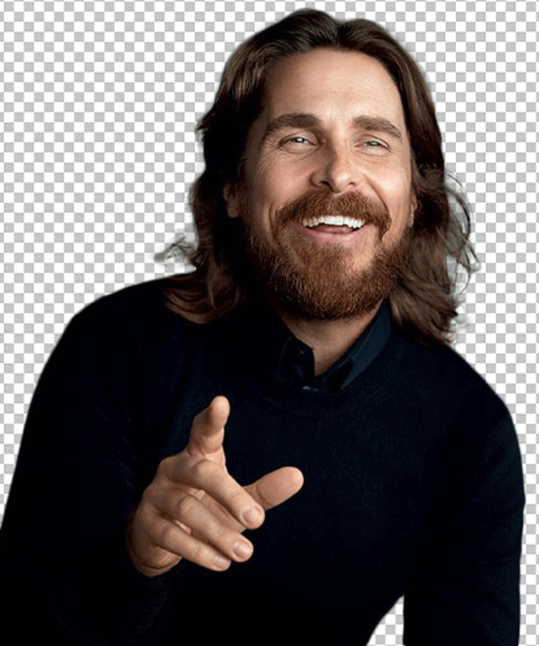 Christian Bale is smiling and pointing.
