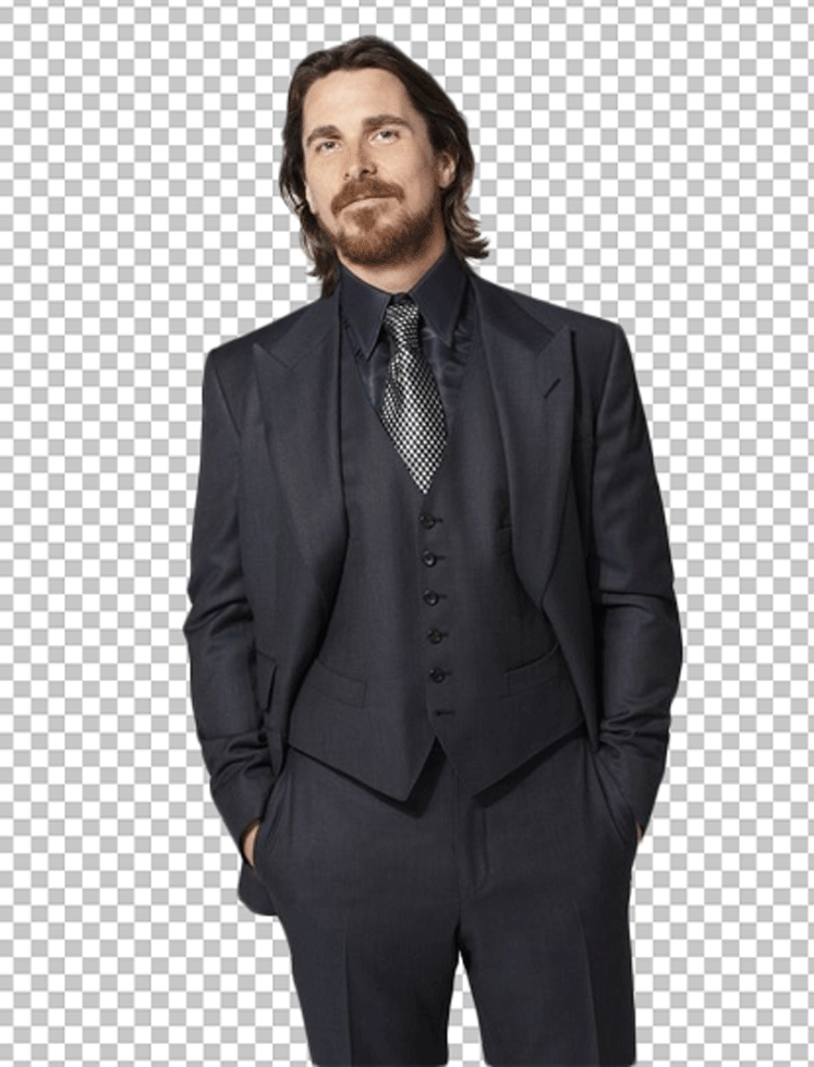 Christian Bale is smiling in his suit.