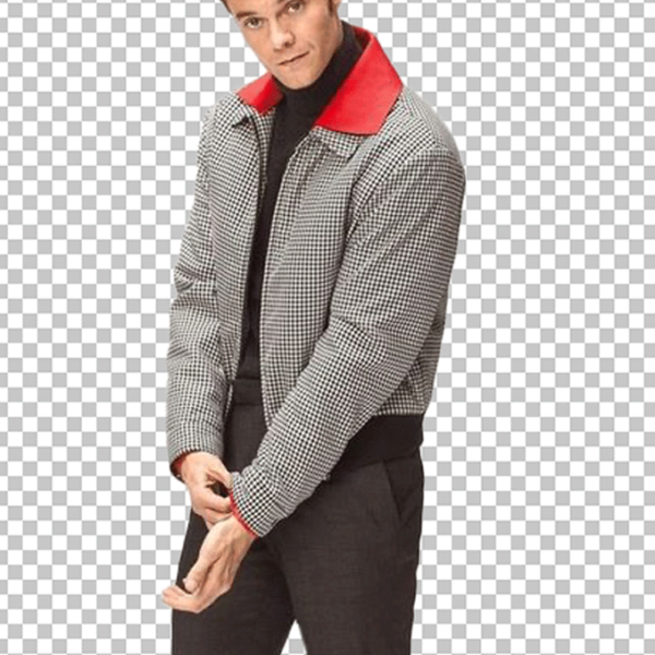 Jack Quaid is standing in a red and white striped jacket, black pants, and black shoes.