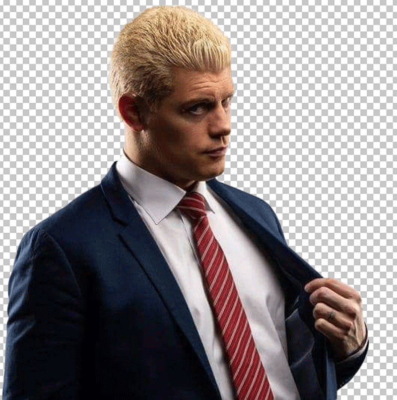 Cody Rhodes looking at a something and in a suit and tie, with blond hair and a serious expression.