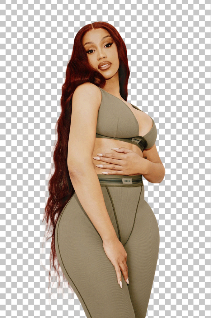 Cardi B with red hair and is wearing a tight-fitting, beige sports bra and leggings.