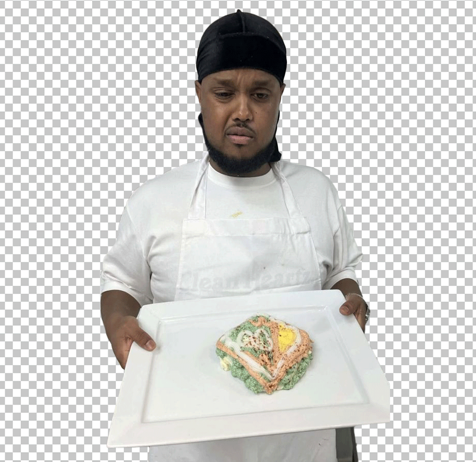 Chunkz as chef is wearing an apron and holding a white plate with a piece of food on it.