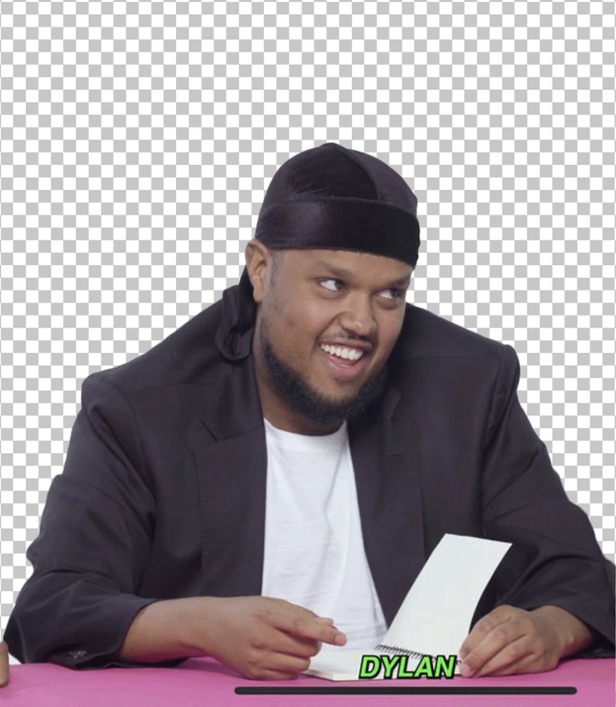 Chunkz is sitting at a table with a piece of paper in front of him.