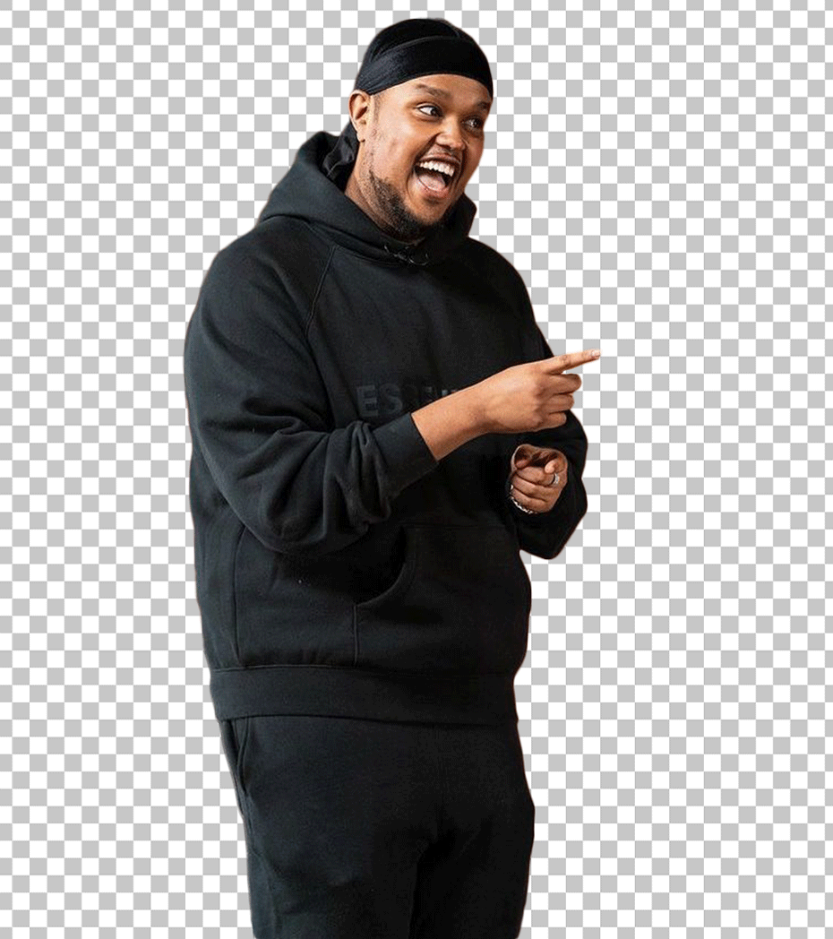 Chunkz is wearing a black hoodie and a black hat, pointing at something with his hand.
