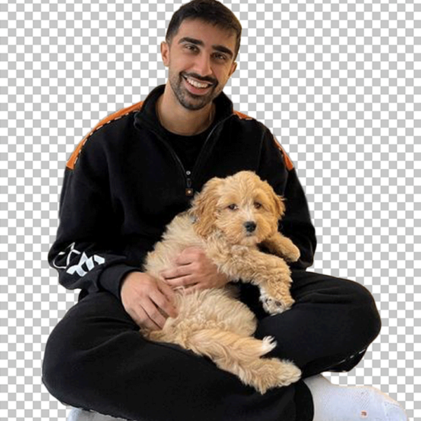 Vikkstar is sitting on the ground, holding a dog.